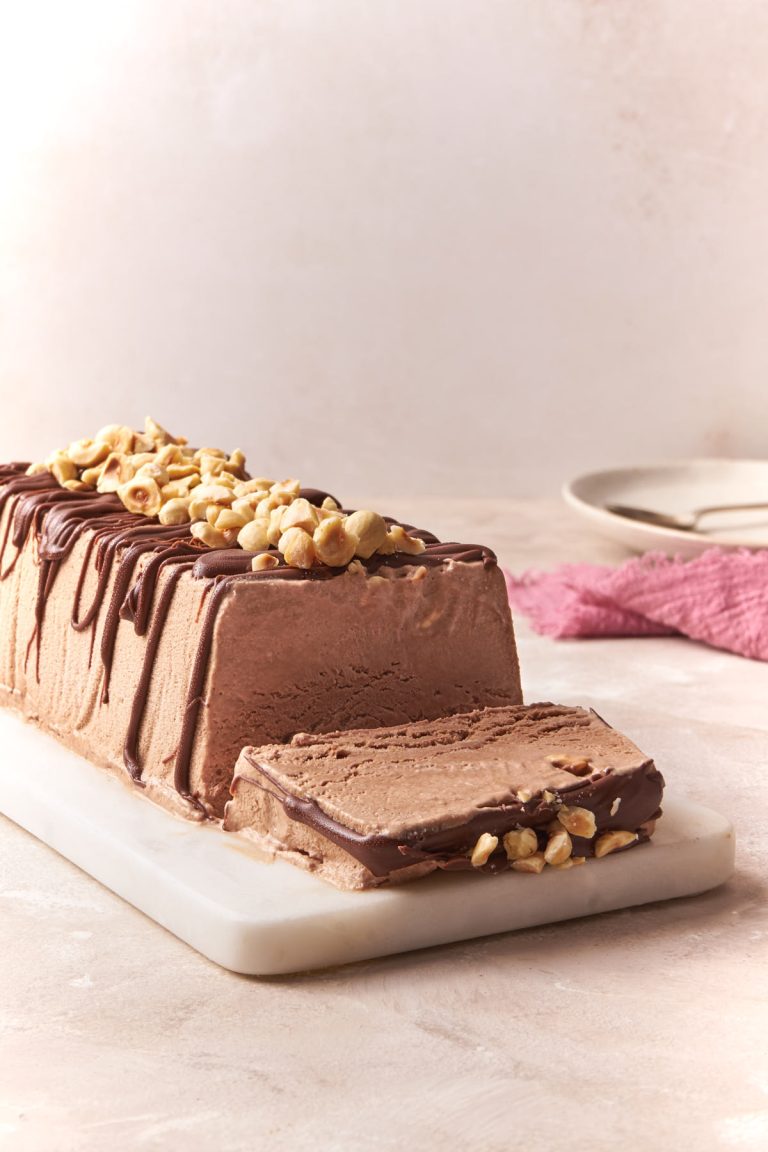 A Nutella semifreddo with dessert plates and spoon in the background.